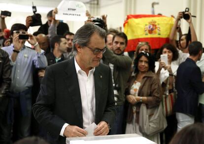 El presidente de la Generalitat y número cuatro en las listas de Junt pel Si, Artur Mas,vota en las elecciones que se celebran hoy en Cataluña mientras varios miembros del VOX exhiben una bandera de España.