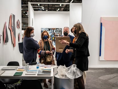 Una empleada de la galería Moisés Pérez de Albéniz muestra una pieza durante la jornada inaugural de la feria Estampa, en Ifema (Madrid).