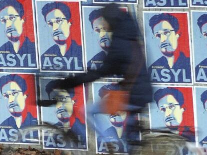 Un ciclista pasa este mi&eacute;rcoles junto a un cartel solicitando asilo para Snowden en Colonia, Alemania.