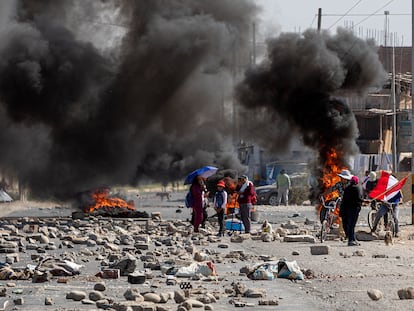 Varias personas caminaban el miércoles entre una barricada levantada durante las manifestaciones en la ciudad peruana de Tacna.