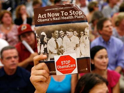 Un manifestante contra la reforma sanitaria muestra una foto de Barack Obama junto a Adolf Hitler, el martes en Reston, Virginia.