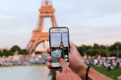 Un hombre se dispone a capturar un &#039;pok&eacute;mon&#039; frente a la Torre Eiffel, en Par&iacute;s.