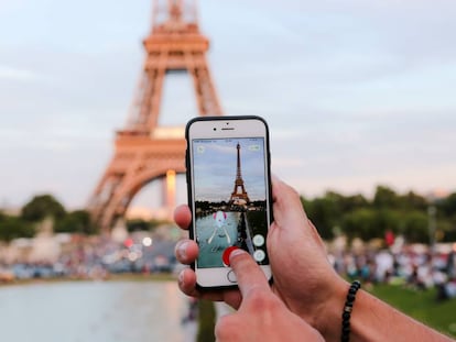 Un hombre se dispone a capturar un &#039;pok&eacute;mon&#039; frente a la Torre Eiffel, en Par&iacute;s.