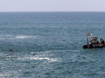 Dos submarinistas y una lancha de la Guardia Civil, durante la búsqueda de inmigrantes desaparecidos el pasado mayo al sur de Gran Canaria.