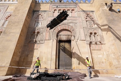 Operarios retiran las vigas de maderas calcinadas de los tejados de la Mezquita de Córdoba, este martes.