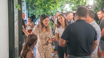 Participantes en la vendimia nocturna de Pago de Tharsys durante la cena previa a la cosecha. En el centro, una de las propietarias de la bodega, Rebeca García.