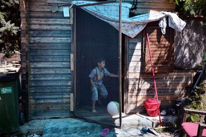 Un niño juega en la puerta de su casa en la 'Village All together' o PIKPA village, en la isla de Lesbos (Grecia).