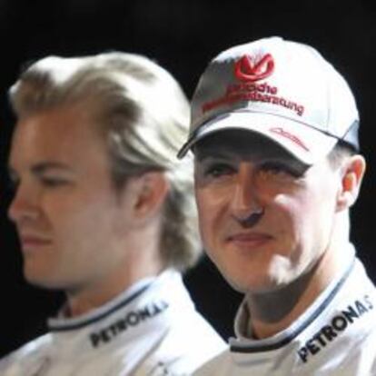 Michael Schumacher y Nico Rosberg, en segundo plano, durante la presentación del equipo Mercedes.