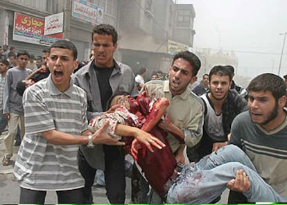 Jóvenes palestinos trasladan el cuerpo de un compañero muerto durante el ataque israelí de ayer en Rafah.