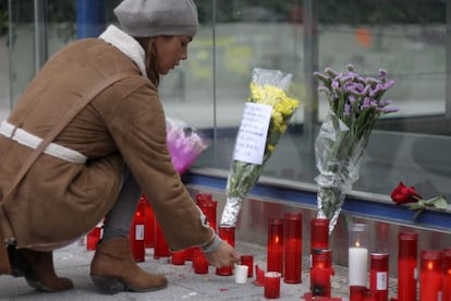 A girl lays flowers at a memorial for the four deceased in the Madrid Arena accident.