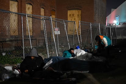 Migrants camp out at night in freezing temperatures in downtown El Paso near a bus station.