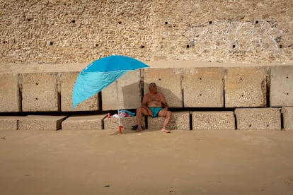 Este martes se ha registrado un ascenso de temperaturas en el norte y sudeste peninsulares y en Baleares. Lo peor, de nuevo, ha estado en los valles del Guadiana y del Guadalquivir, donde por tercer día consecutivo se han rozado o superado los 43°. Los termómetros han estado por encima de 35° en amplias zonas de la meseta Norte, Alto Ebro, sur de Galicia, interior del Cantábrico oriental y Mallorca, y por encima de 40° en el valle del Ebro. En el centro y sur peninsulares se han alcanzado o superado también los 40°. En la imagen, un hombre se refugia del sol bajo una sombrilla, en una playa de Cádiz. 