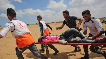 Un palestino herido por las protestas en la frontera de Gaza es evacuado por sanitarios.