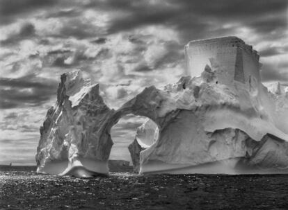 Iceberg entre la Isla Paulet y las Islas Shetland del Sur, en el Mar de Weddell. A nivel del mar, los niveles de flotación anteriores son claramente visibles en el hielo que ha sido pulido por el movimiento constante del océano. En lo alto, una forma semejante a una torre del castillo ha sido tallada por la erosión eólica y las piezas adosadas de hielo. Península Antártica. Enero y febrero de 2005.