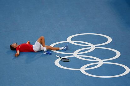 El tenista español Pablo Carreño se tira al suelo tras conseguir su medalla de bronce en los Juegos Olímpicos de Tokio frente a Djokovic, el 31 de julio.