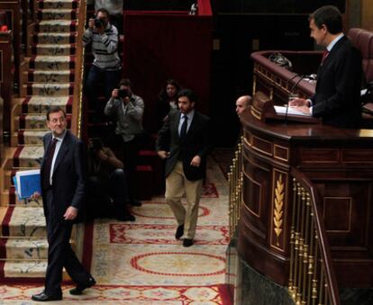 Rajoy llega a su escaño mientras Zapatero ya se dirige al hemiciclo durante el debate monográfico en el Congreso sobre la situación del empleo en España.