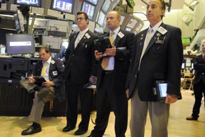 Un grupo de corredores de Bolsa observa en un panel del mercado de Nueva York la abrupta caída del Dow Jones.