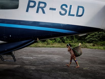 Un niño indígena camina cerca de un avión usado por personal del gobierno brasiñero en Roraima, el 10 de enero 2024.