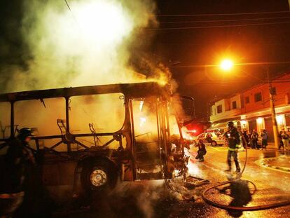 Bombeiros apagam chamas de &ocirc;nibus incendiado por integrantes do PCC na Vila Madalena, zona oeste de S&atilde;o Paulo, em maio de 2006. V&aacute;rios &ocirc;nibus foram incendiados naquela semana. 