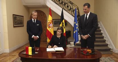 Queen Letizia signs a book of condolence in the presence of King Felipe (right) and the Belgian ambassador.