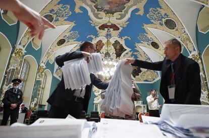 Miembros de la Comisión Electoral cuentan votos en un centro de votación en la estación de tren de Kazán, en Moscú, este domingo.
