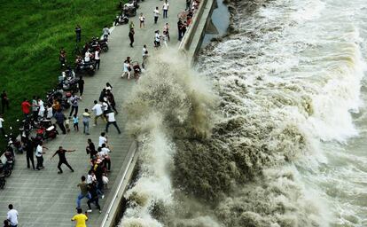 Una gran ola rompe la barrera e inunda el paseo a orillas del río Qiantang en Hangzhou, China.