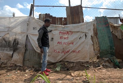 Kaka muestra una tela en la que está escrito: ‘La pobreza no es un accidente, está creada por el ser humano’. El 78% de los jóvenes en Kenia están en el paro. 
