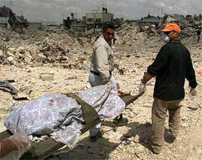 Dos palestinos cargaban ayer con el cadáver de uno de los muertos en el campo de Yenín.