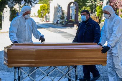 Enterradores del cementerio Monumental de Bérgamo trasladan un ataúd este lunes.