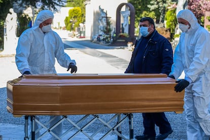 Enterradores del cementerio Monumental de Bérgamo trasladan un ataúd este lunes.