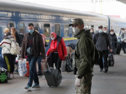 Un guardia fronterizo con guantes y mascarilla, este domingo en la estación de tren de Kiev.