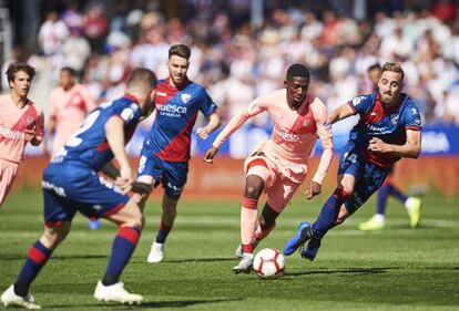 Ousmane Dembele flanqueado por los jugadores del Huesca.