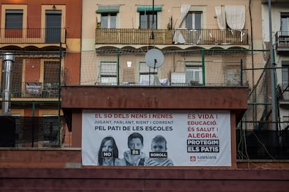 Patio de la escuela Salesians Rocafort con carteles de protesta contra el cierre del patio por exceso de ruido.