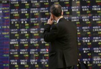 Un hombre mira una pantalla electrónica con el cierre de la Bolsa de Tokio. EFE/Archivo