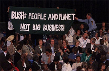 El servicio de seguridad retira una pancarta contra la política medioambiental de EE UU en la clausura de la cumbre.