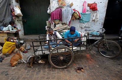 Varias personas comen comida en su hogar improvisado en Calcuta (India).