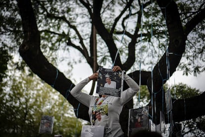 Miembros del colectivo 'Luciérnagas. Frente Amplio de Familias Buscadoras de Justicia en la Ciudad de México' colgaron fotografías de sus familiares desaparecidos en un árbol al que bautizaron 'árbol de la memoria', frente a la Fiscalía General de Justicia de la Capital, este viernes. 