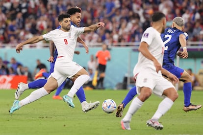 Doha (Qatar), 29/11/2022.- El jugador iraní, Mehdi Taremi, se lleva el balón ante Weston McKennie, de EE UU.