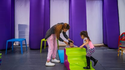 Una madre con sus hijos en una unidad de cuidado en Bogotá, en 2022.