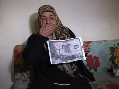 Uma sobrevivente mostra uma foto sua junto aos cadáveres de sua família.