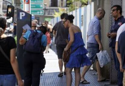 Un controlador enseña a una usuaria a utilizar el parquímetro.