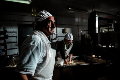 Julio Gómez, en la quesería. Al fondo, la educadora social Sandra Fernández, que además de acompañar la formación de los aprendices, hace lo que haga falta, sea ayudar en la elaboración del queso o venderlo en la trastienda.  