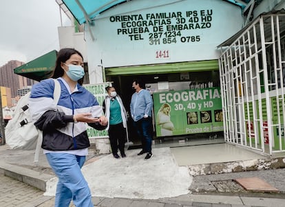 Una joven pasa por delante de clínica de ecografías en la avenida Caracas en Bogotá.