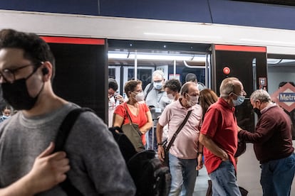 Varios pasajeros salen de un vagón en el metro de Madrid. 
