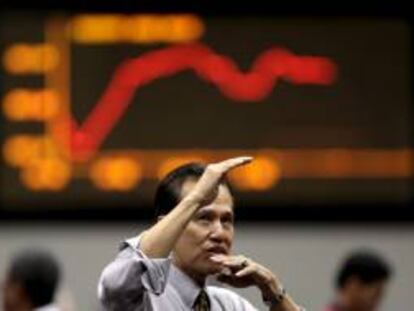 Un corredor de la Bolsa de Filipinas gesticula frente a una pantalla con índices económicos en el distrito financiero de Makati, en Manila (Filipinas). EFE/Archivo