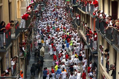 Mozos corren delante de los toros de la ganadería de Dolores Aguirre Ybarra, en el tramo de la calle Estafeta.