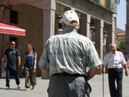 Un jubilado pasea por una calle en Madrid. 
