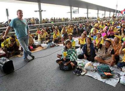 Un turista británico rodeado de manifestantes opositores al Gobierno en el aeropuerto de Bangkok.