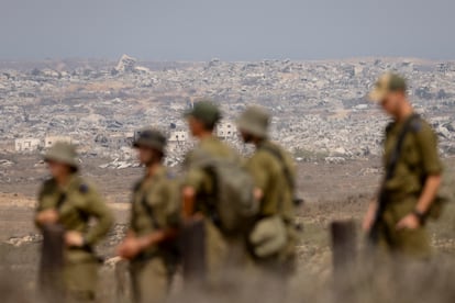 Unos soldados israelíes observan los edificios destruidos en el norte de la Franja de Gaza desde un mirador situado en el lado israelí de la frontera, el 13 de agosto de 2025.
