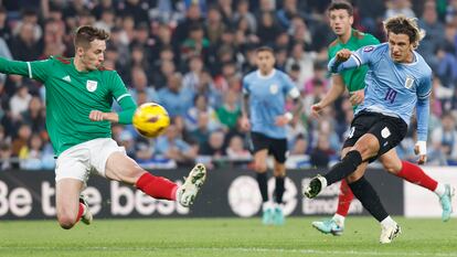 Pacheco (i) se lanza ante el jugador de Uruguay, Agustían Canobbio, durante el amistoso.